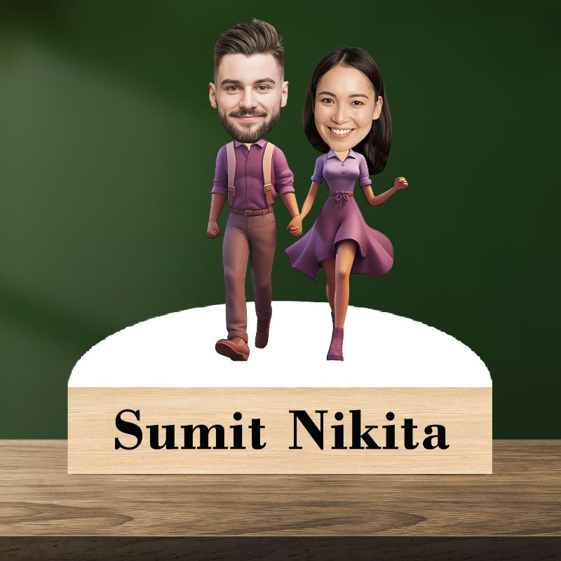 A 3D caricature of a couple, with the man wearing a purple shirt and the woman in a purple dress, standing on a round platform with the text 'SUMIT NIKITA' at the bottom.