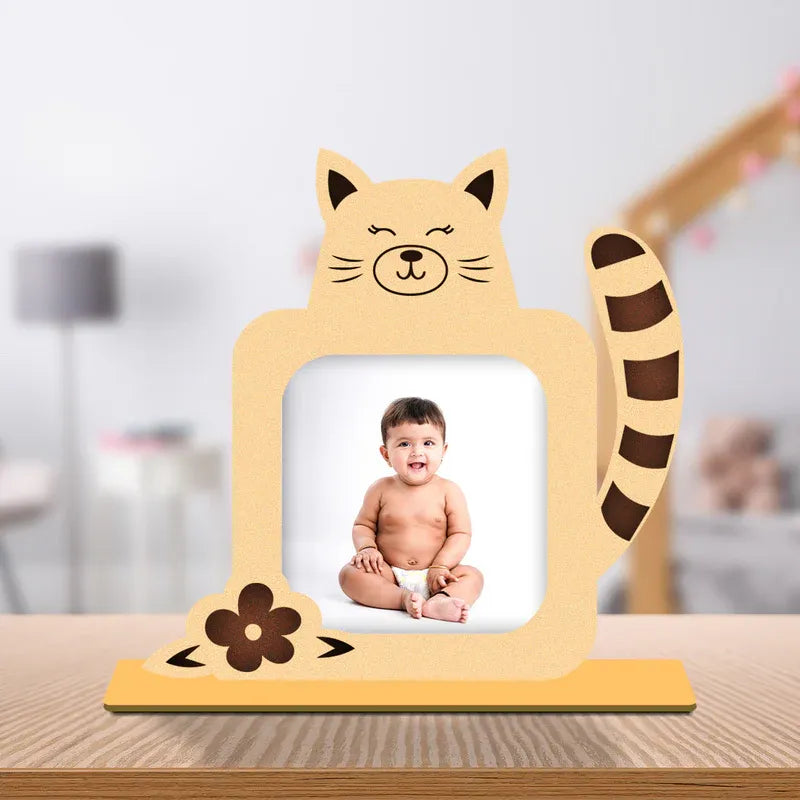 Cat baby photo frame — personalised warm peach wooden cat shaped frame with striped tail flower detail and custom baby photo on yellow wooden base, unique newborn gift from Zingy Gifts India.