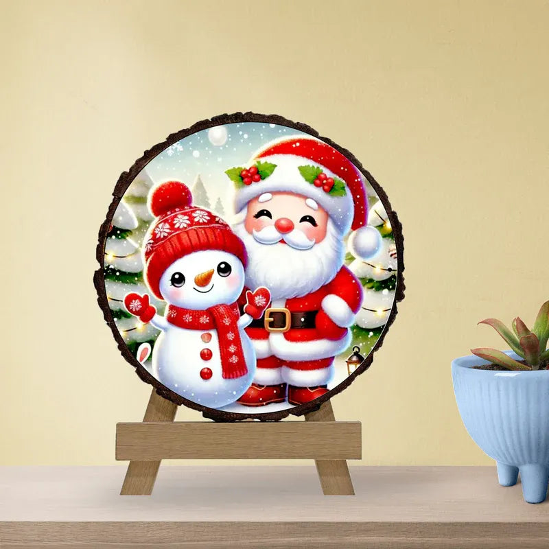 Decorative wall art with Santa Claus and a snowman on a wooden stand against a beige wall.