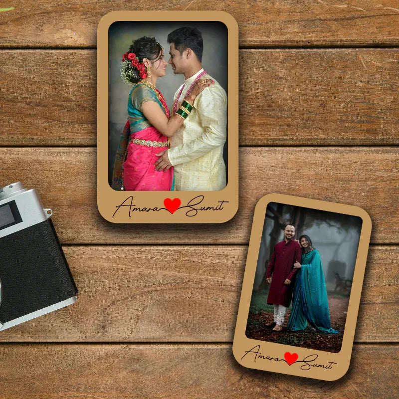 Two wooden photo fridge magnet with a couple in traditional attire on a wooden surface.