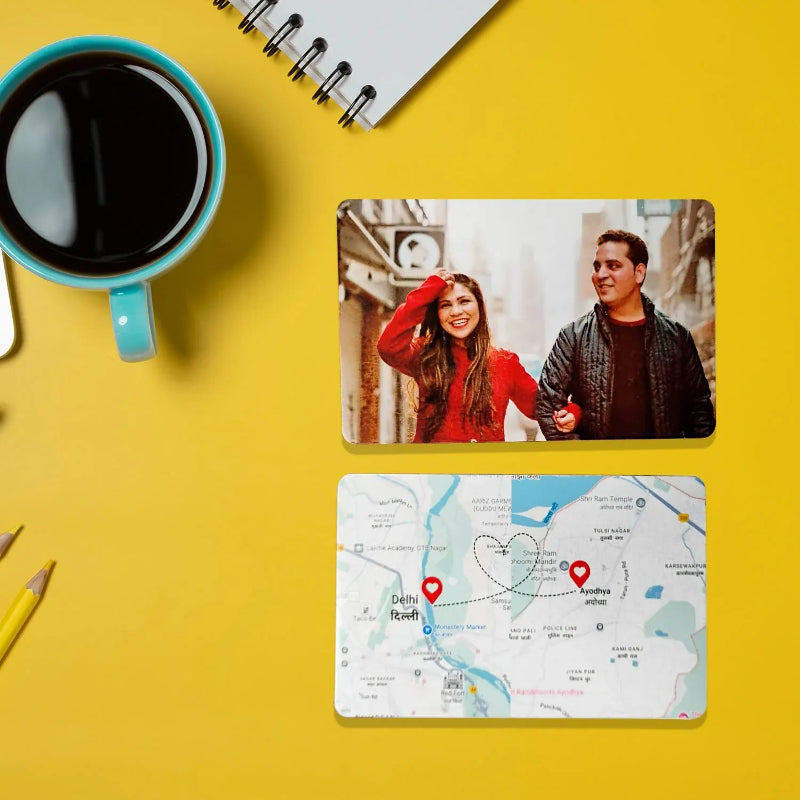 Two people on a photo card with a map of India, a cup of coffee, and a pencil on a yellow background.