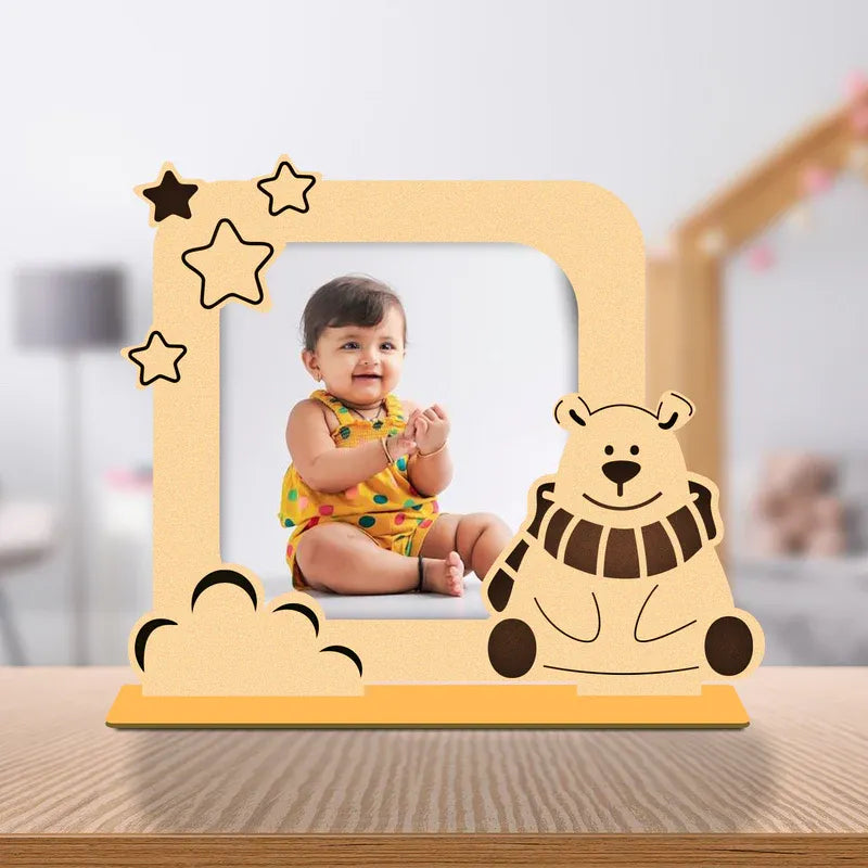 Wooden photo frame with a bear design and a child's photo inside, on a wooden surface.