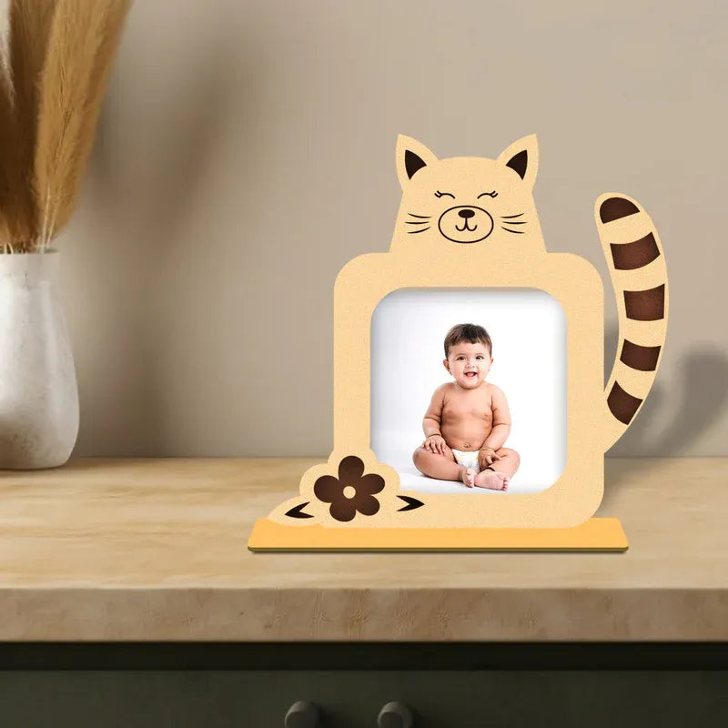 Custom baby photo frame — peach wooden cat shaped personalised 
frame with striped tail flower detail and smiling baby photo displayed on wooden shelf, unique baby shower gift India from Zingy Gifts.