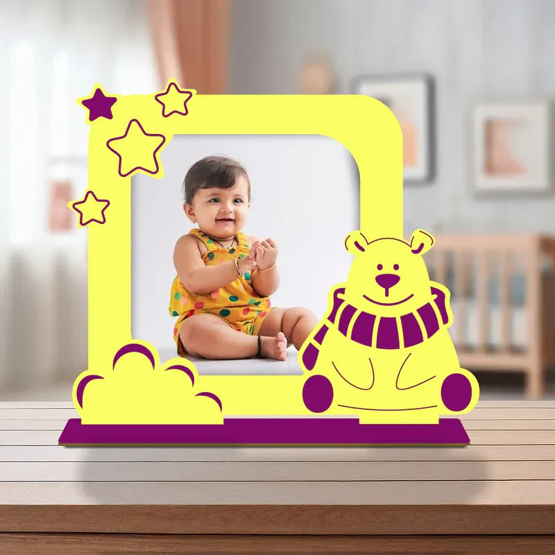 Yellow baby photo frame with cartoon bear and stars, containing a photo of a baby.
