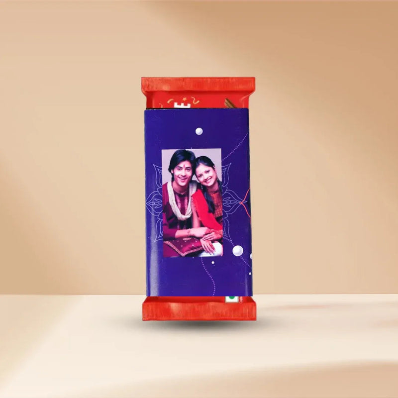 A custom chocolate bar wrapper featuring a deep purple background with a printed photo of two women, accented by red top and bottom bands, set against a warm beige background.