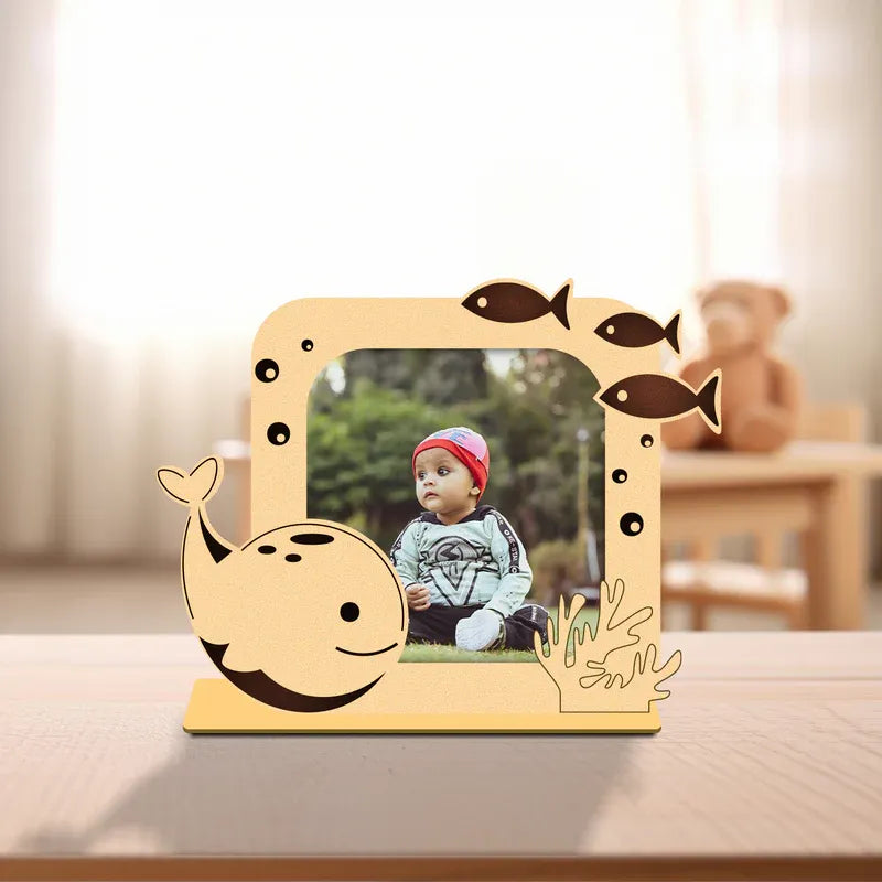Wooden photo frame with whale and fish design on a table
