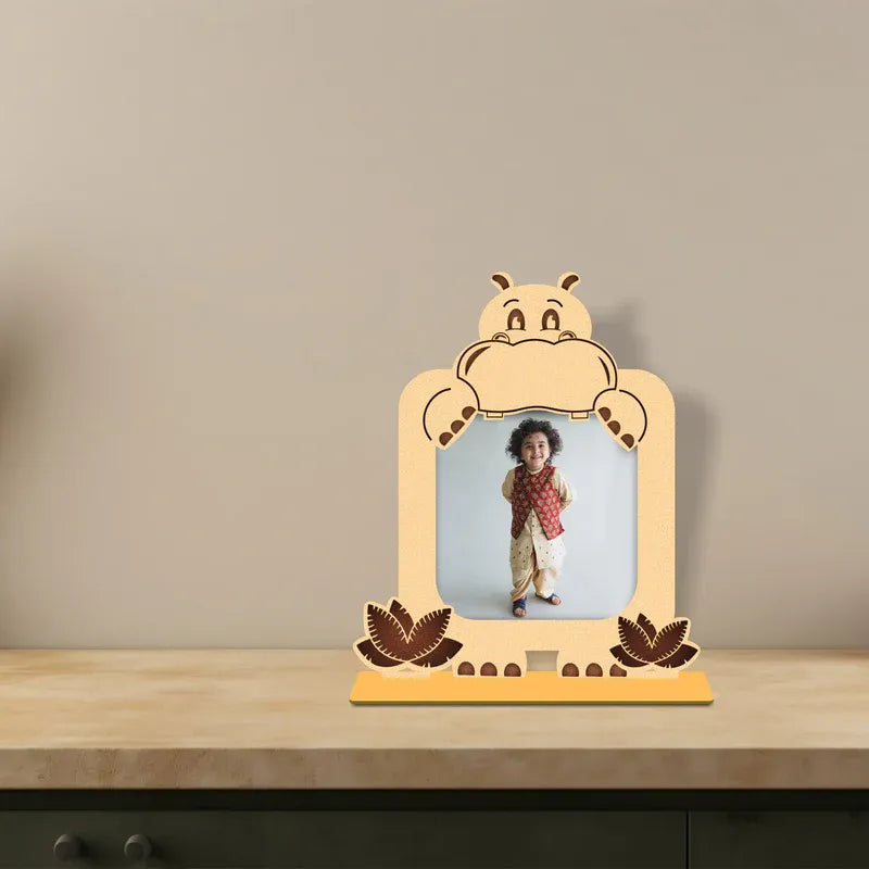 Personalized wooden hippo baby photo frame placed on a minimal table with a child’s photo, warm neutral background and soft lighting.
