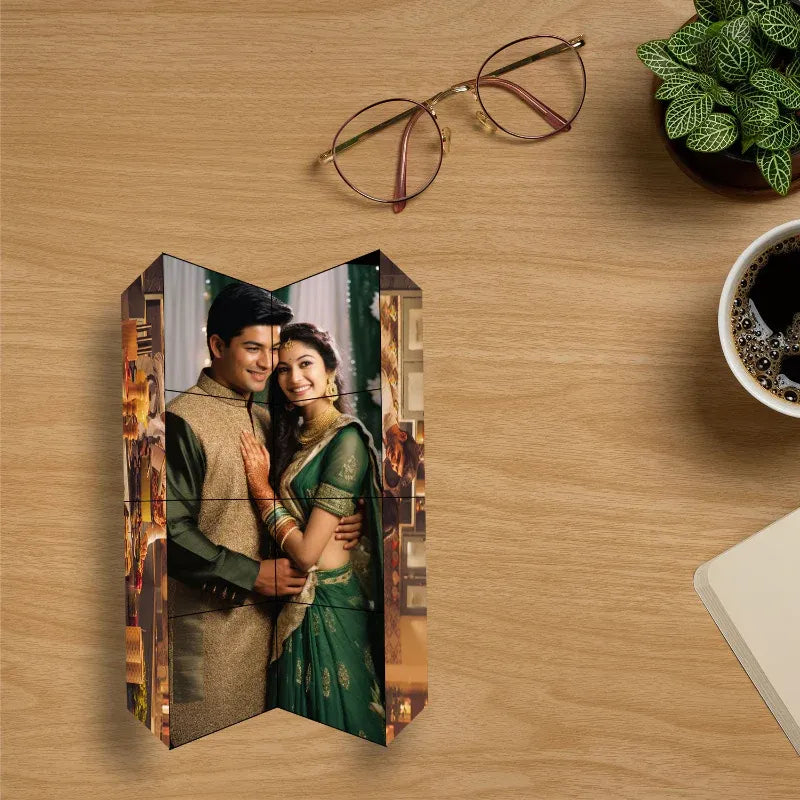 Wooden photo block with a couple in traditional attire on a wooden surface with glasses and a plant.