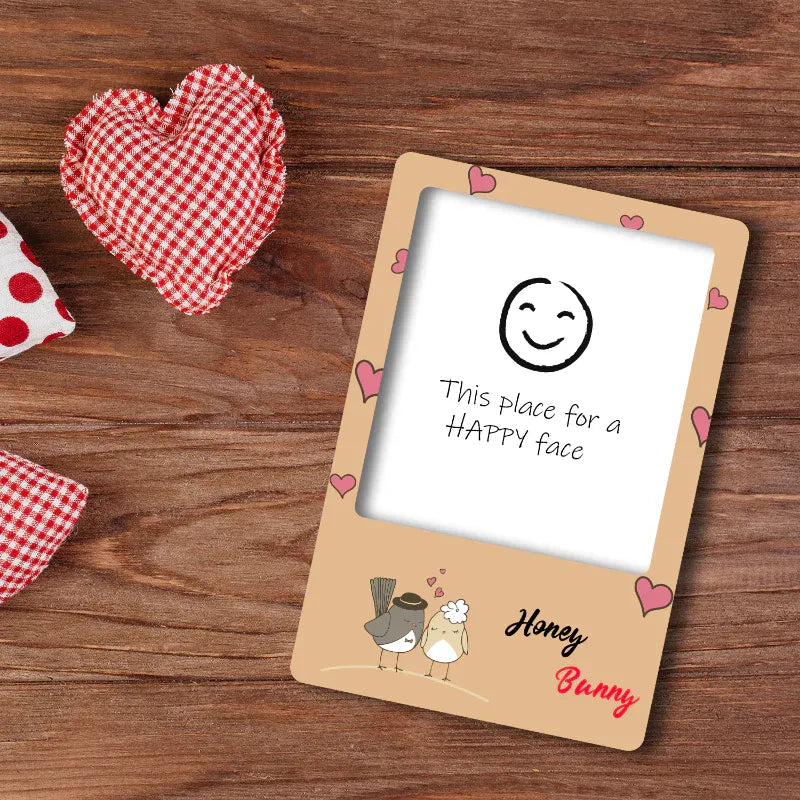 Custom photo frame with a smiley face illustration on a wooden surface with heart-shaped objects.