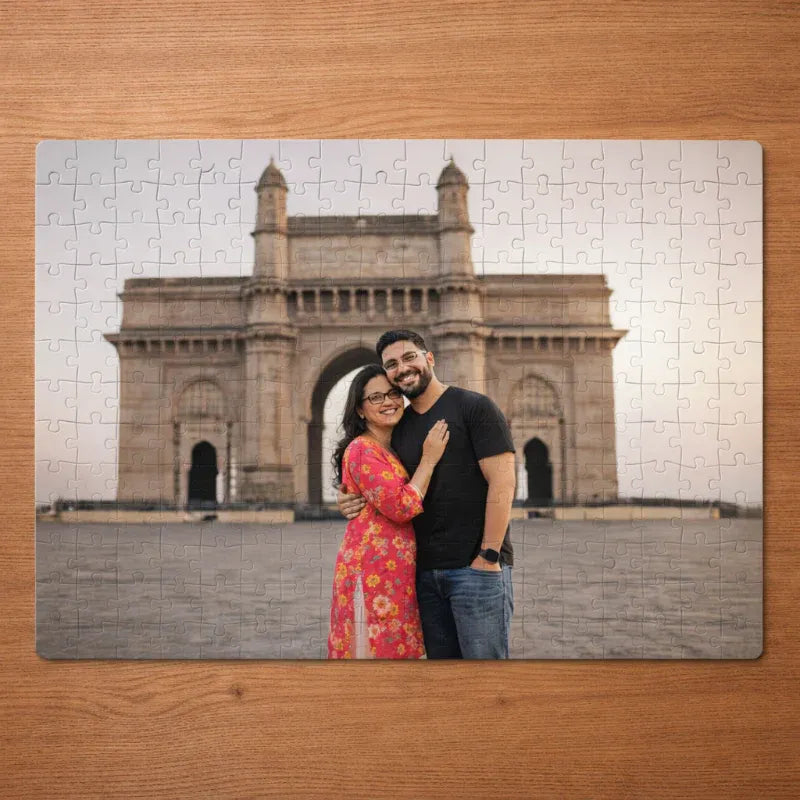 Jigsaw puzzle with a couple in front of the Gateway of India on a wooden surface