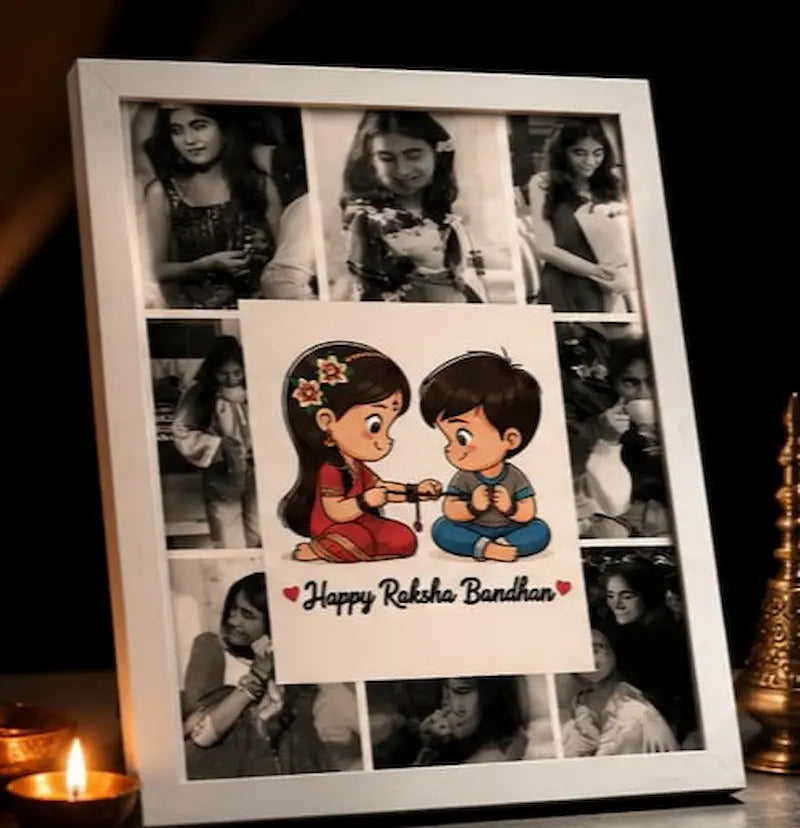 A white square photo frame displayed on a dark surface, containing a collage of black-and-white family photos and a central printed illustration of a cartoon boy and girl with the text 'Happy Raksha Bandhan' written below. Lit candles are visible at the bottom corners.