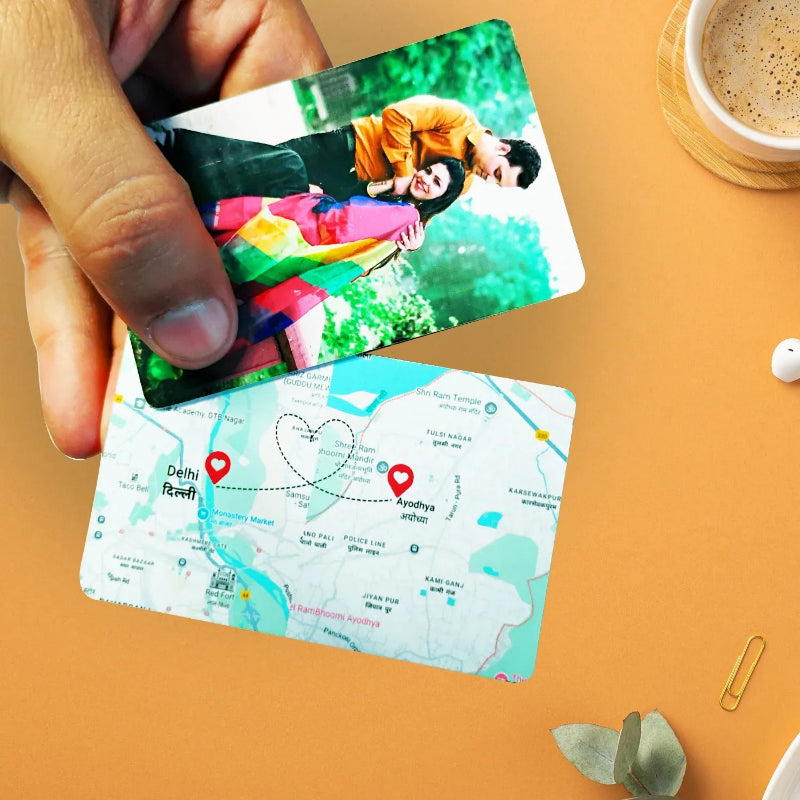 Two photo cards, one with a couple and another with a map, held by a hand on an orange surface.