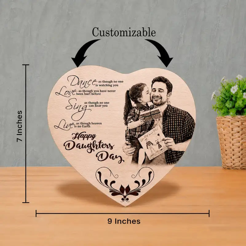 Heart-shaped wooden plaque with customizable photo and text, shown on a wooden table with dimension markers indicating 7 inches height and 9 inches width, plus arrows labeled 'Customizable'.