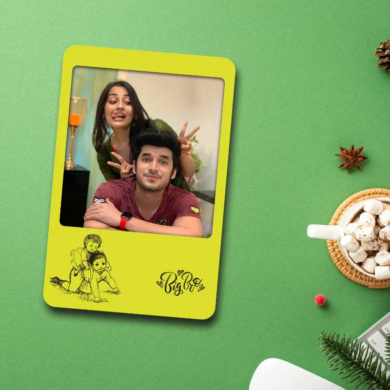 fridge magnet photo frame with a siblings photo on a green background with festive decorations.