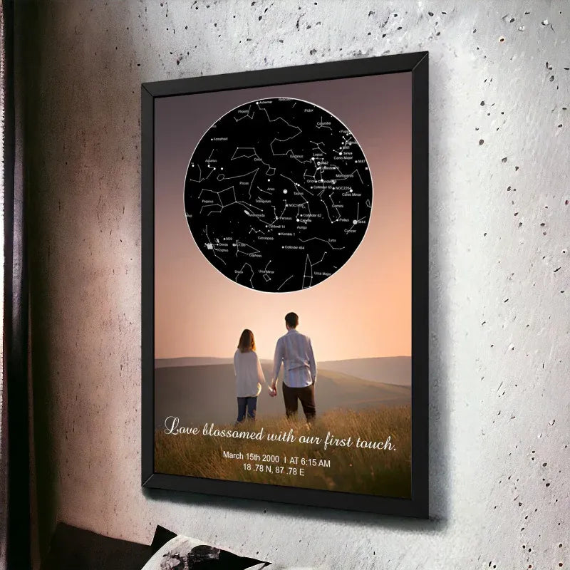 Framed artwork of a couple holding hands with a sunset background and constellation map.