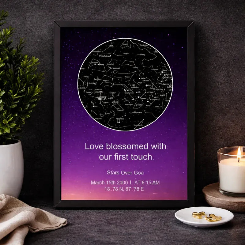 Framed star map poster with personalized message on a dark surface with decorative items.
