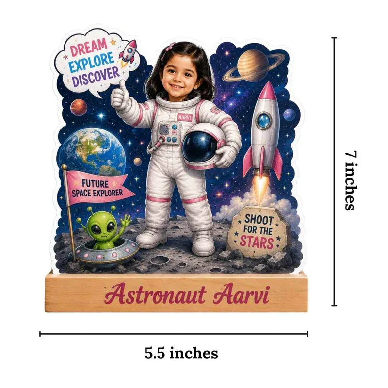 Figurine of a child in an astronaut suit with space-themed elements and text.
