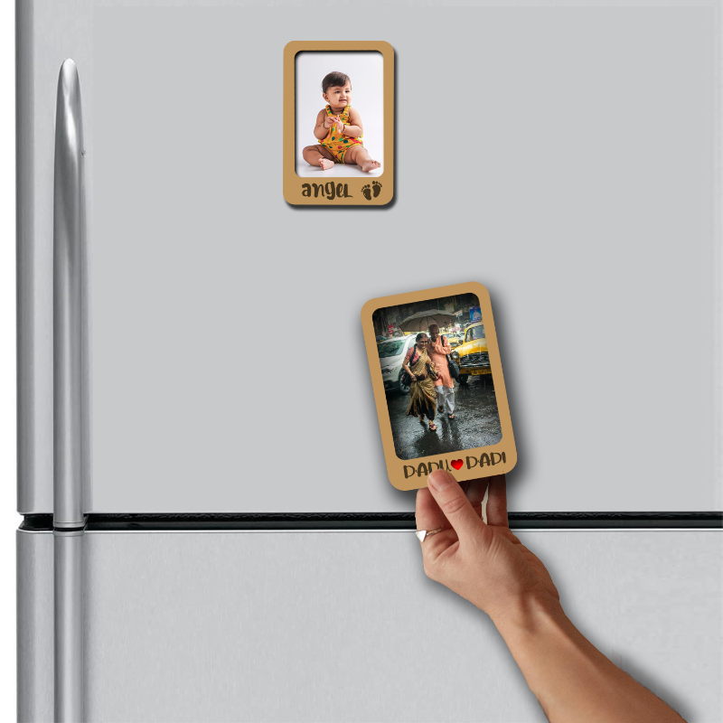 Hand placing a wooden photo frame magnet on a refrigerator with another magnet already attached.