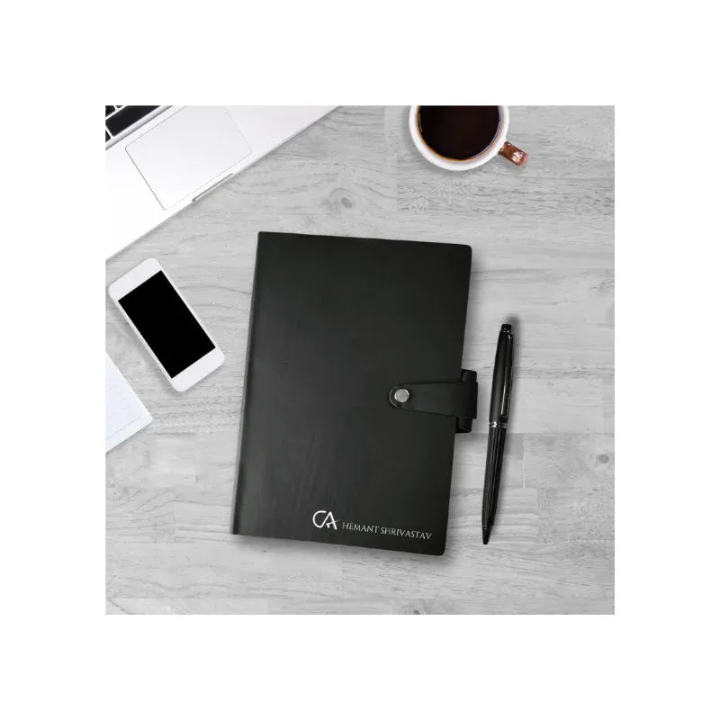 Black planner with a pen and smartphone on a gray surface