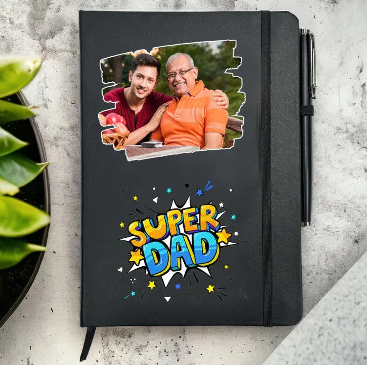 Black notebook with 'Super Dad' design and photo of two men on a gray surface.