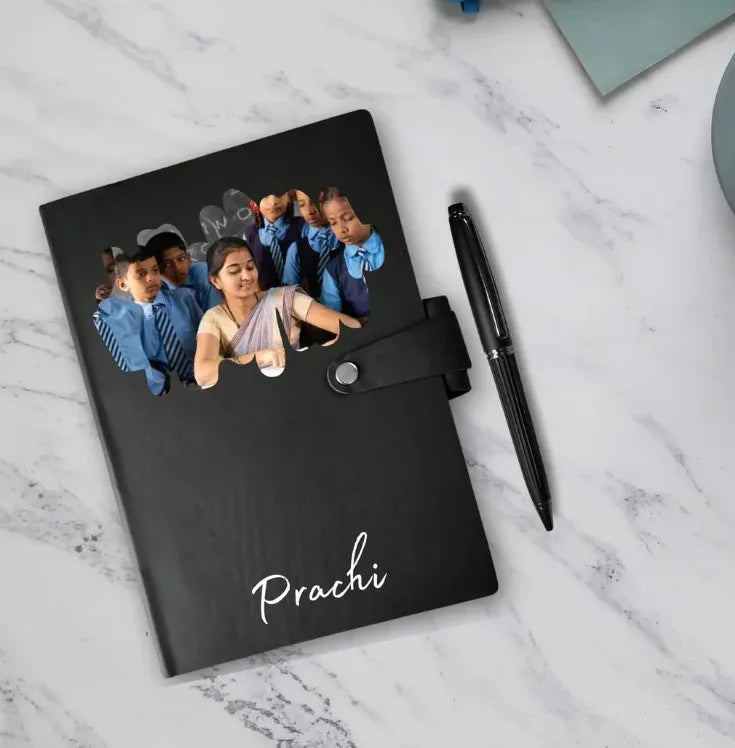 Black notebook with a photo of children and the name 'Prachi' on a marble surface.