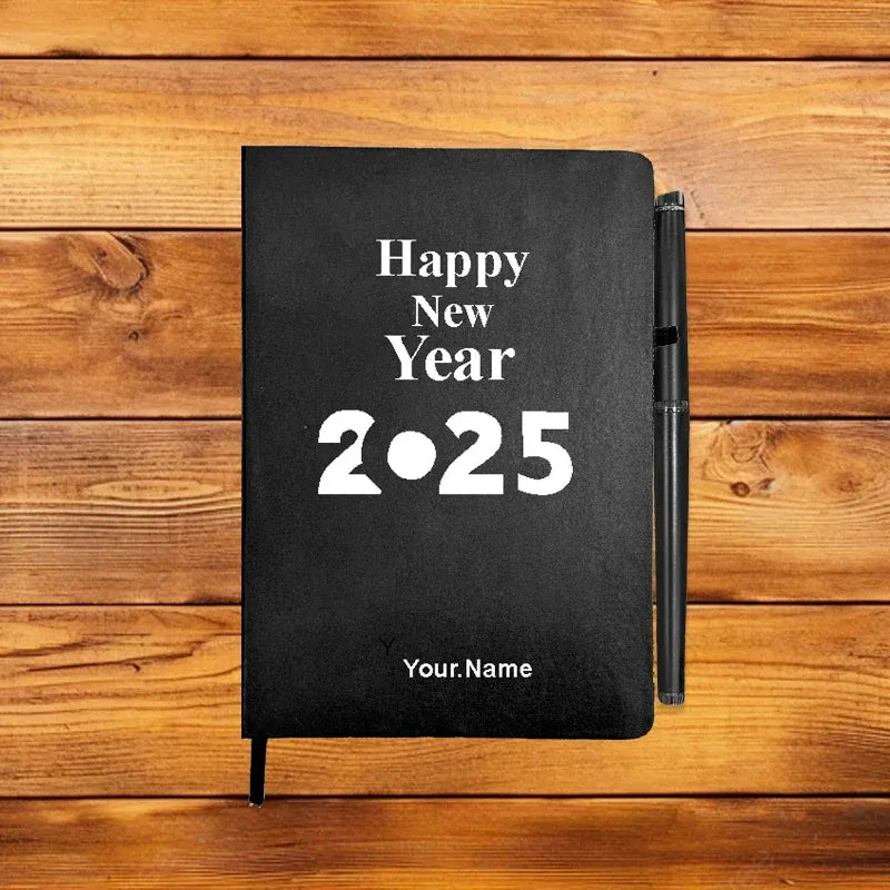 Black notebook with 'Happy New Year 2025' text on a wooden surface
