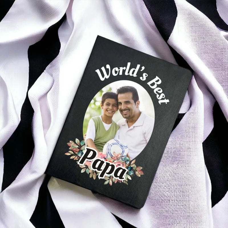 Personalized photo album with 'World's Best Papa' text on a white and black striped fabric background