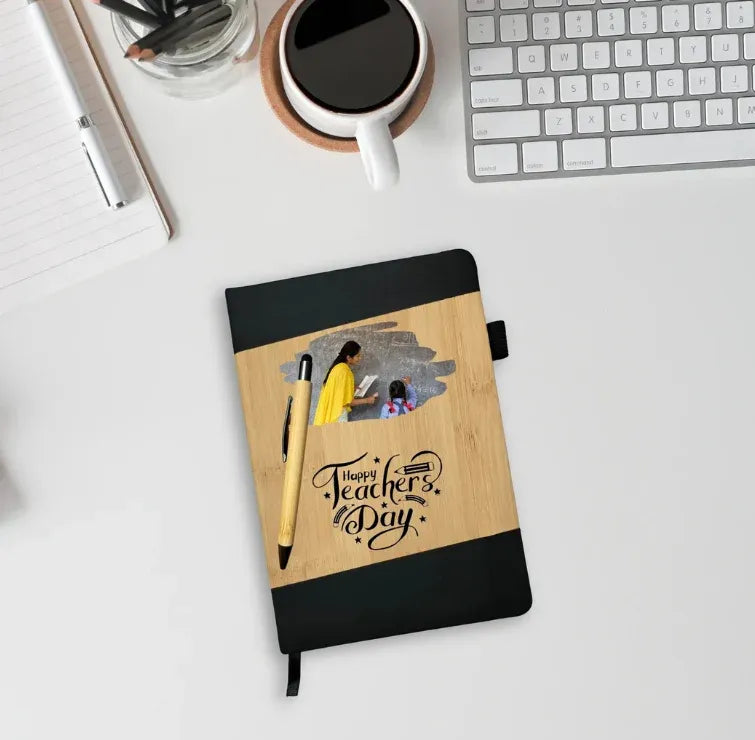 Notebook with 'Happy Teachers' Day' design on a desk with a cup of coffee and keyboard.