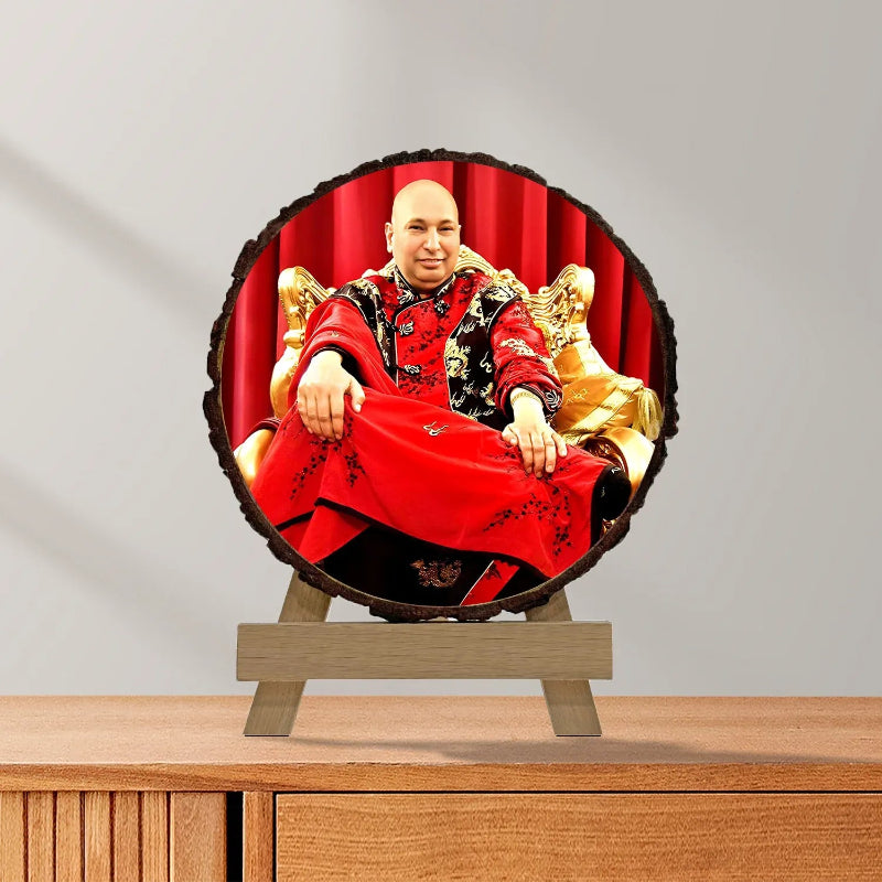 Round decorative item with a person in red and gold attire on a wooden stand against a gray background
