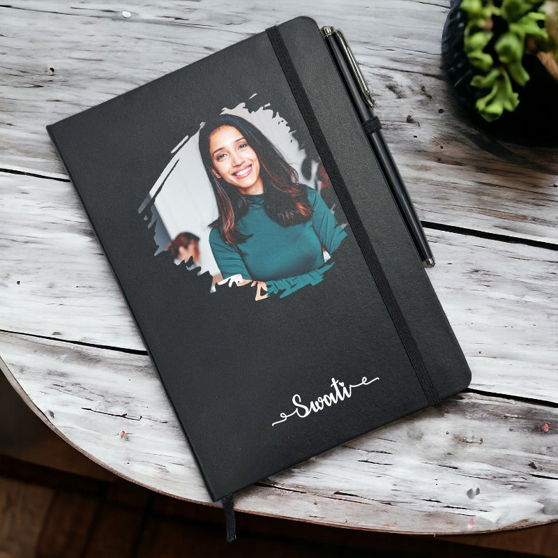Black notebook with a personalized photo and name on a wooden surface
