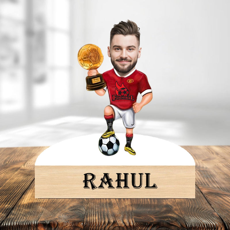 Football player caricature holding a trophy with 'RAHUL' on a wooden base.