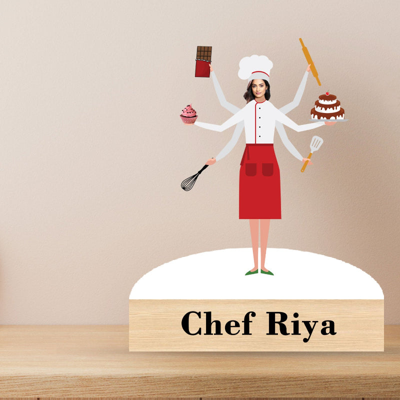 Custom caricature of a female chef with multiple arms, each holding different kitchen utensils and a cake, standing on a base with the name 'Chef Riya' engraved.