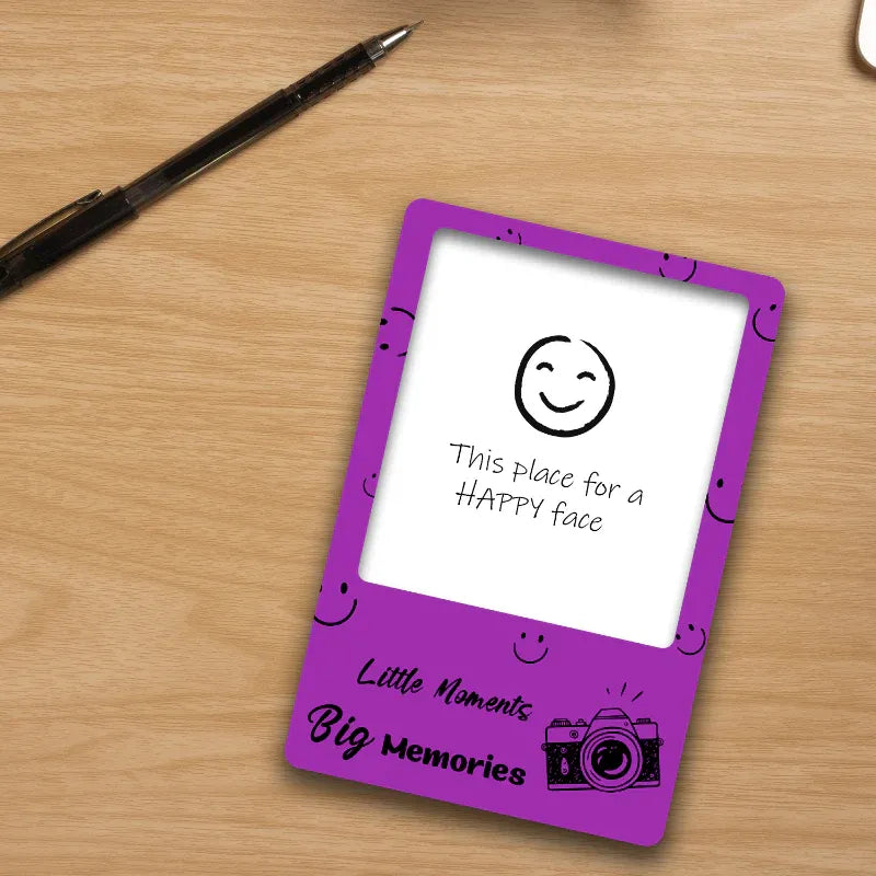 Purple card with smiley face design on a wooden surface with a pen.