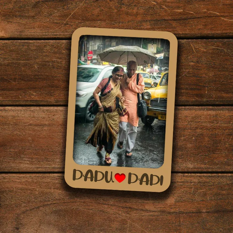 Memorable moment between a father and daughter under an umbrella on a wooden surface with 'DADU DADI' text.