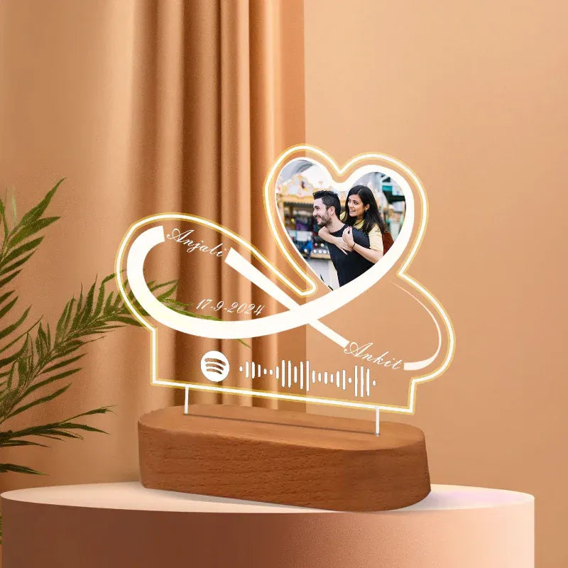 Heart-shaped LED lamp with a wooden base on a peach-colored background