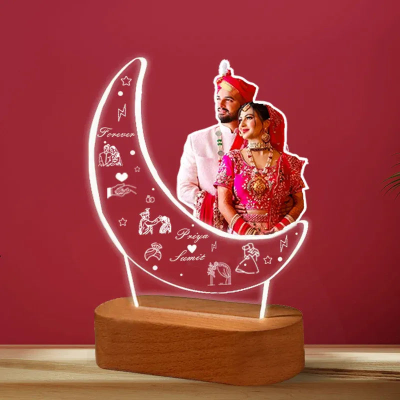 Personalized LED lamp with a couple's photo on a crescent moon design against a red background.