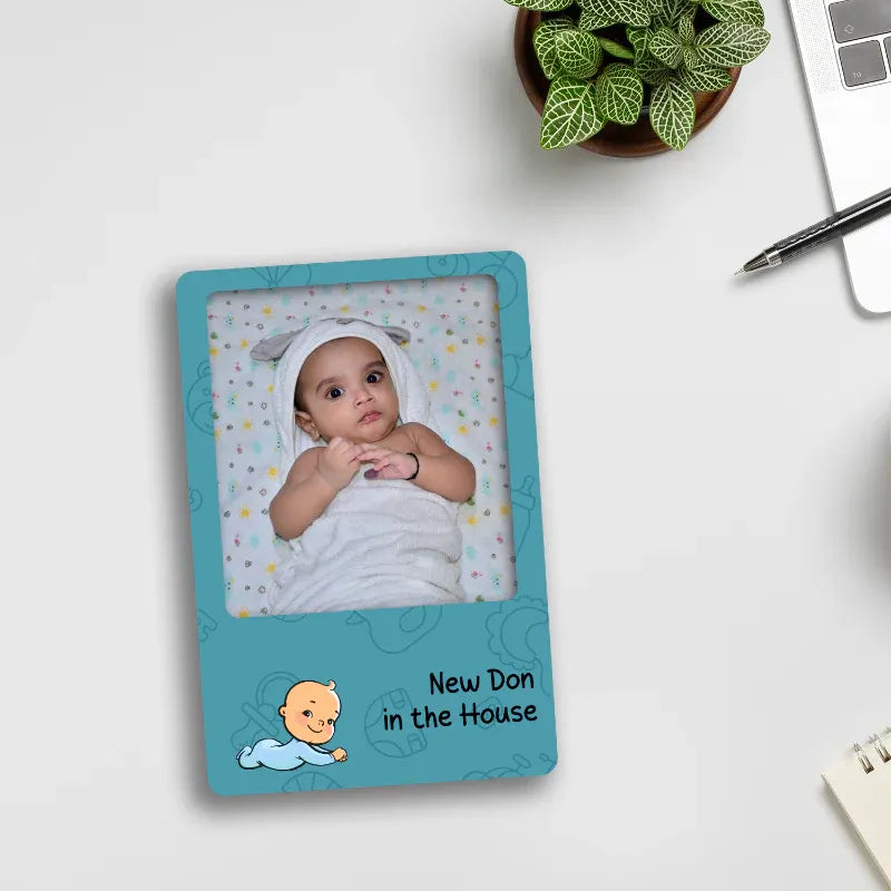 photo fridge magnet with a baby picture and text on a white surface.