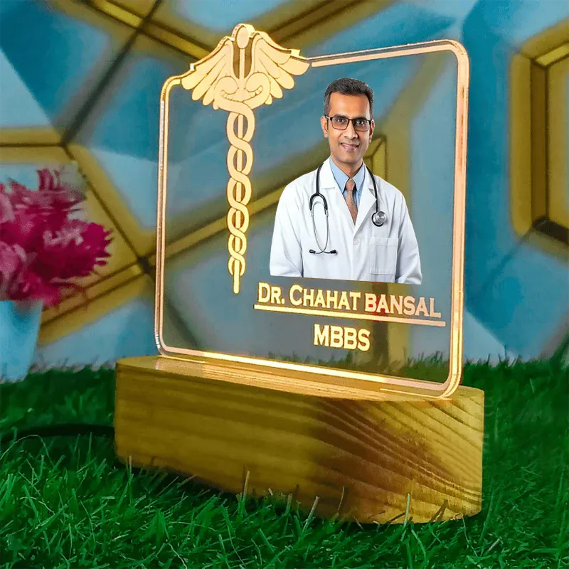 Decorative plaque with a doctor's photo and name on a grassy surface with flowers in the background