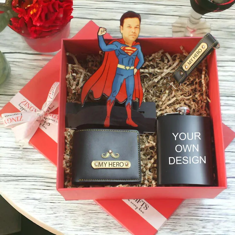 Gift set with superhero figurine, wallet, and flask in a red box on a wooden surface.