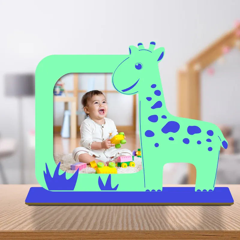 Giraffe baby photo frame — personalised bright green acrylic giraffe shaped frame with blue spots grass detail and custom laughing baby photo on blue wooden base, unique newborn nursery gift from Zingy Gifts India.