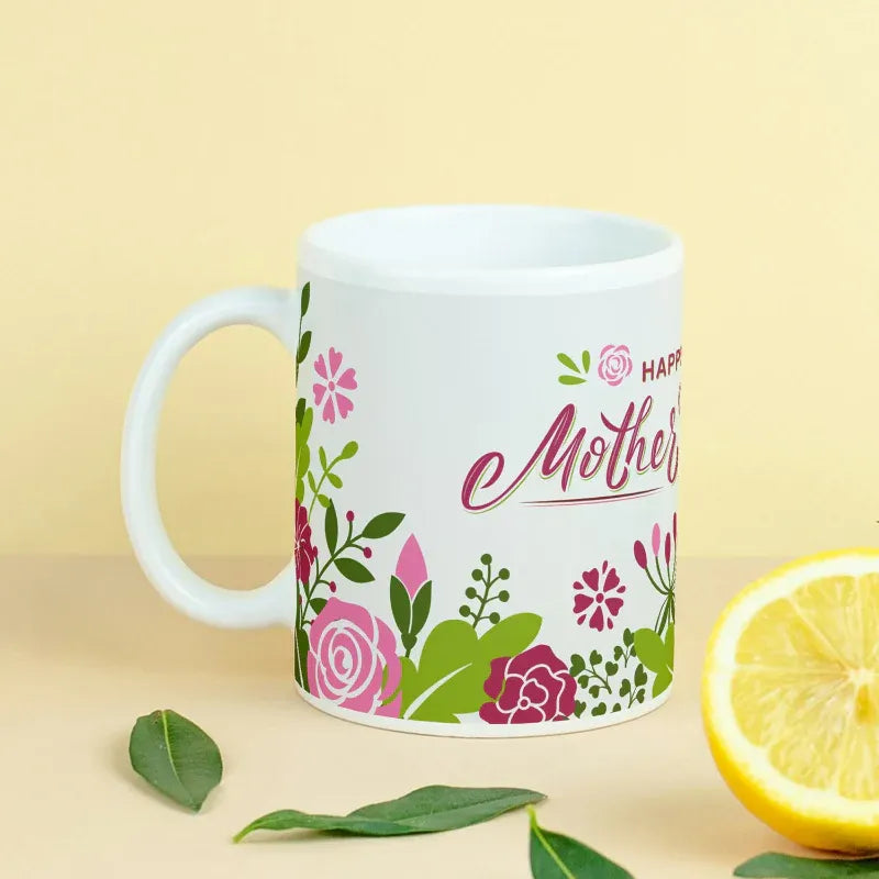 White mug with floral design and 'Happy Mother's Day' text on a yellow background