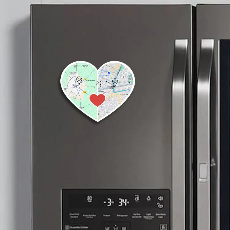 Heart-shaped map magnet with a red heart on a refrigerator door.