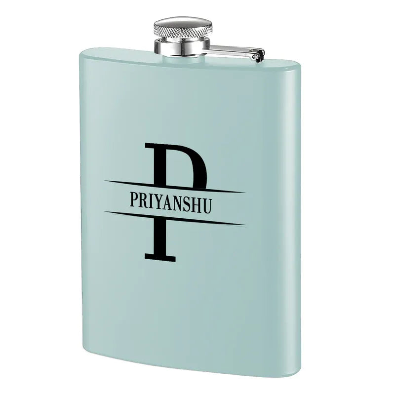 A custom hip flask in blue color with a silver cap and the engraved initial 'P' along with the text 'PRIYANSHU' on the front.