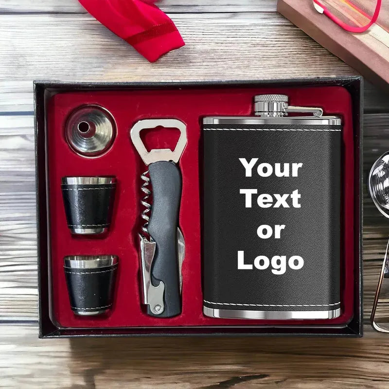 Black flask set with cups, opener, and corkscrew in a box on a wooden surface.