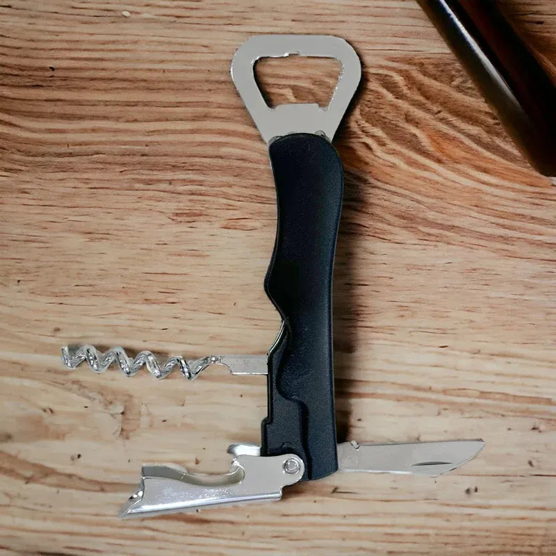 Multi-tool with bottle opener, knife, and corkscrew on a wooden surface