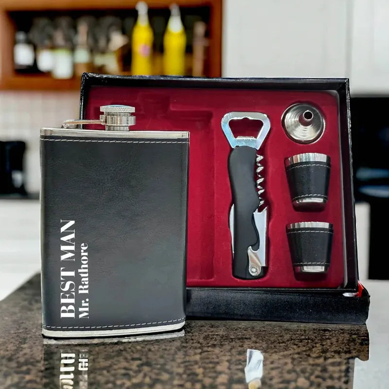 Black leather flask set with 'Best Man' engraving on a counter.