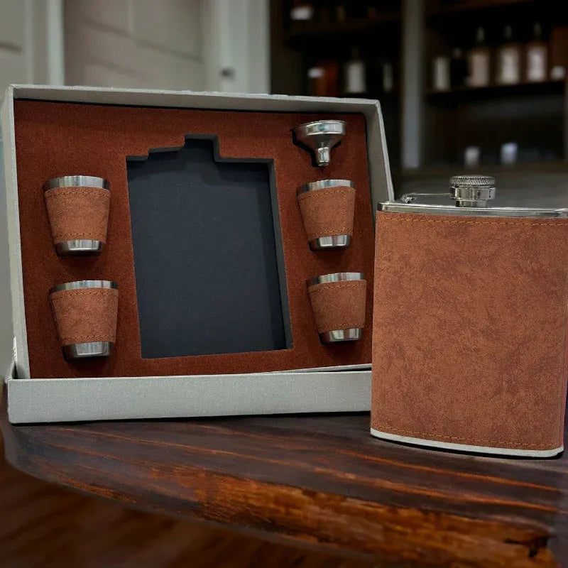 Brown leather flask set with four cups on a wooden surface