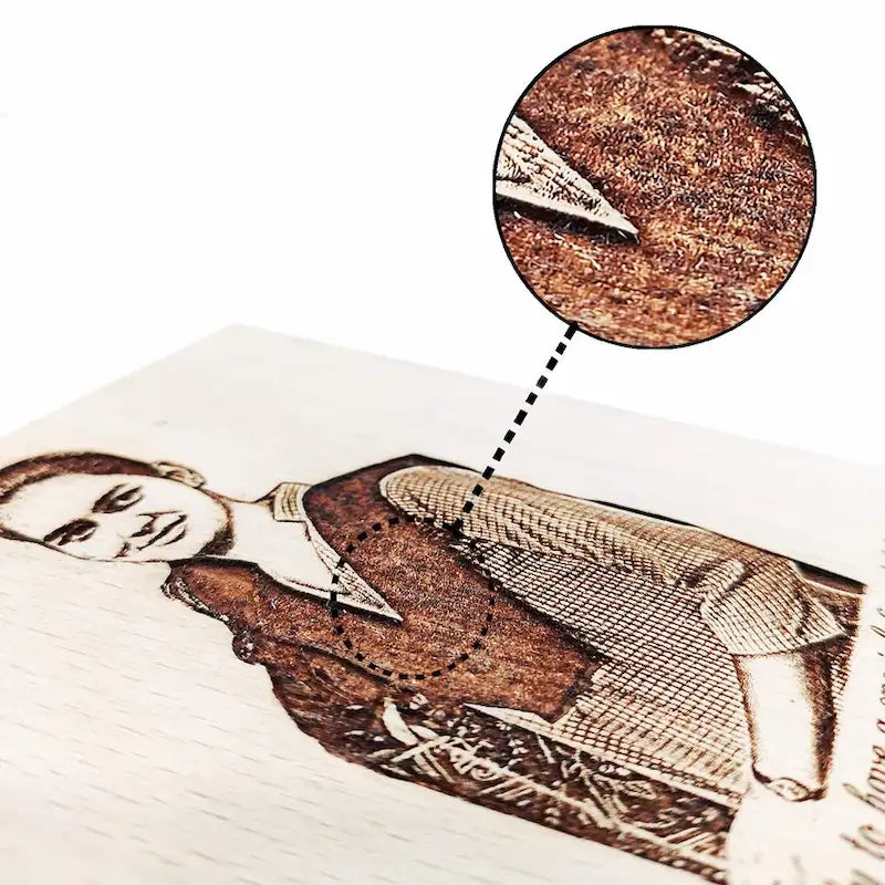 A close-up of a custom laser-engraved portrait of a man on a light-colored wooden plaque, with a circular inset detail showing the textured wood grain and engraving finish.