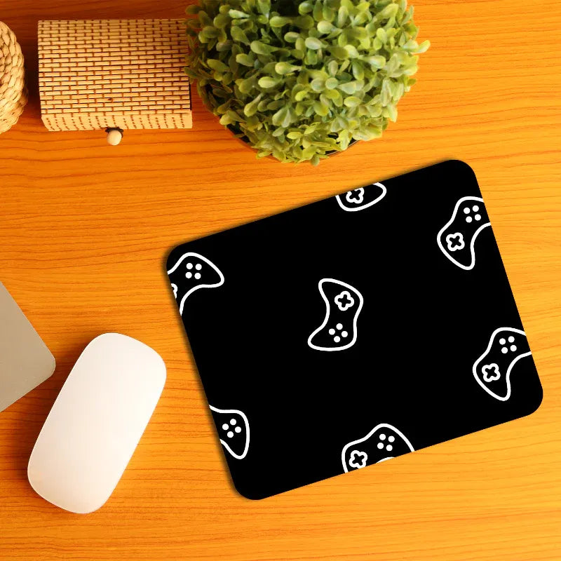Black mouse pad with white joystick pattern on a wooden surface