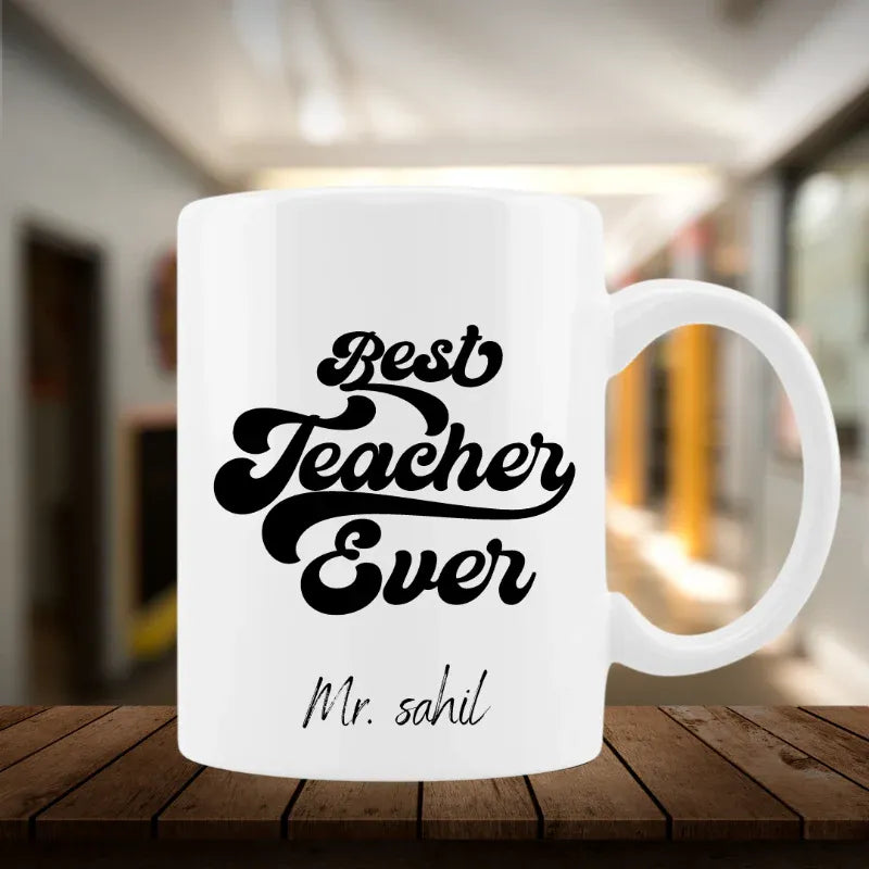 White mug with 'Best Teacher Ever' text on a wooden surface